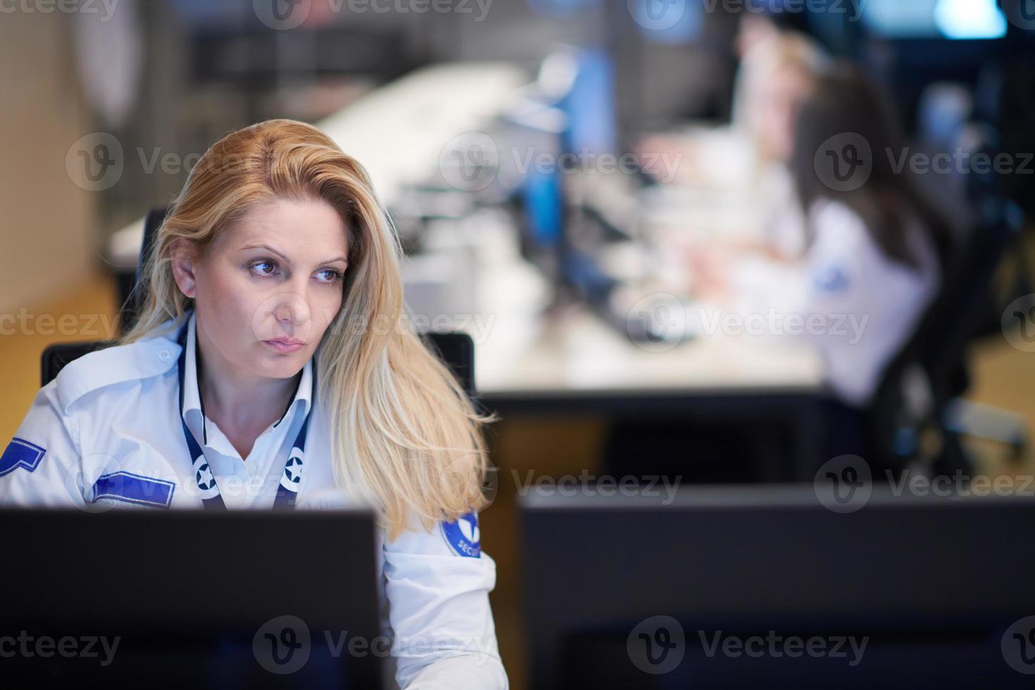 Female operator working in a security data system control room photo