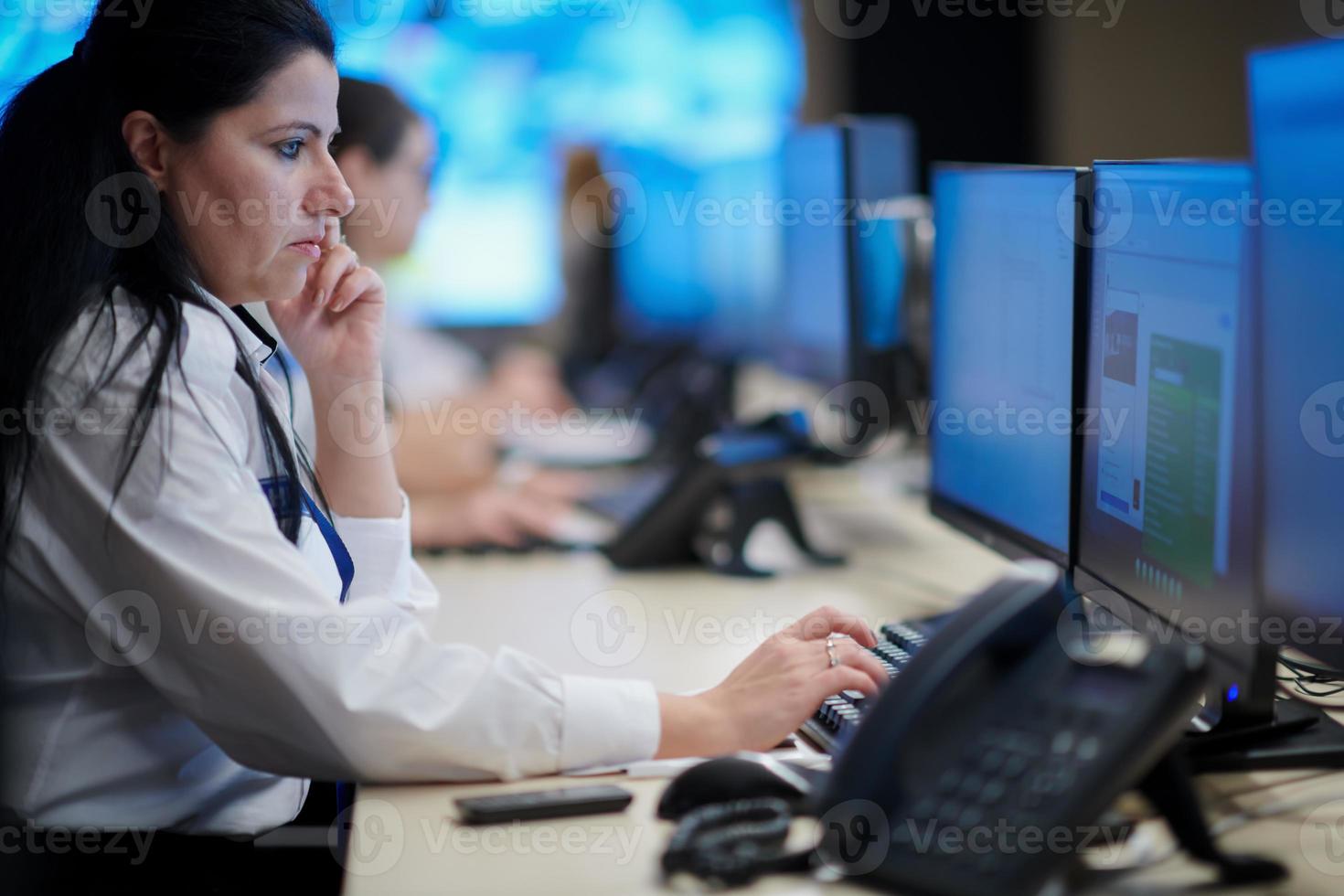 Female operator working in a security data system control room photo