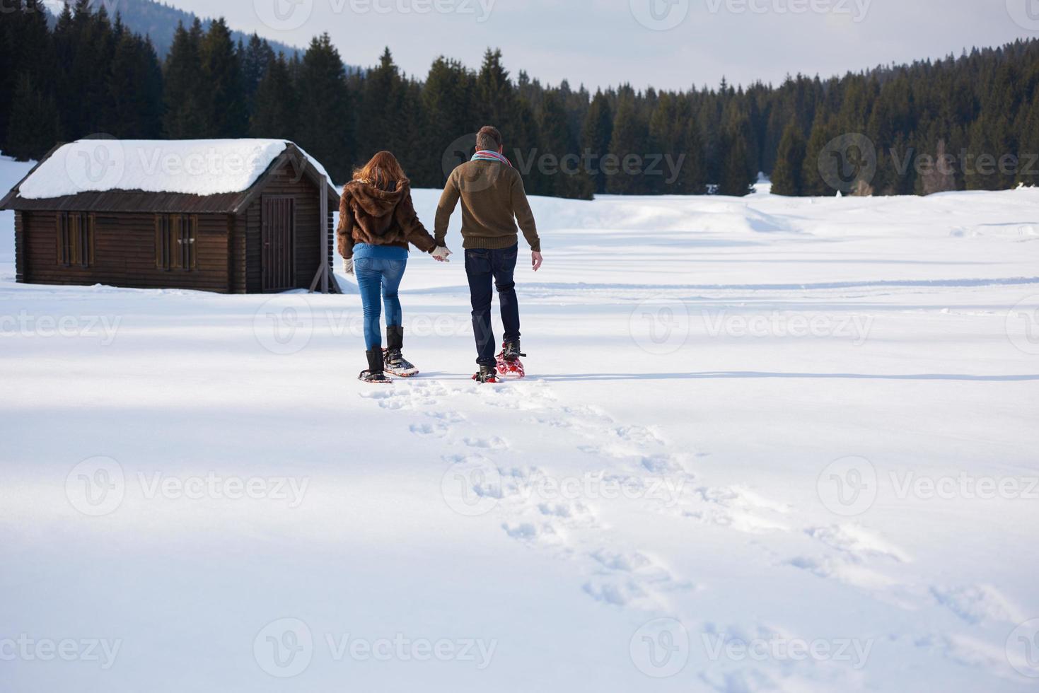 couple having fun and walking in snow shoes photo
