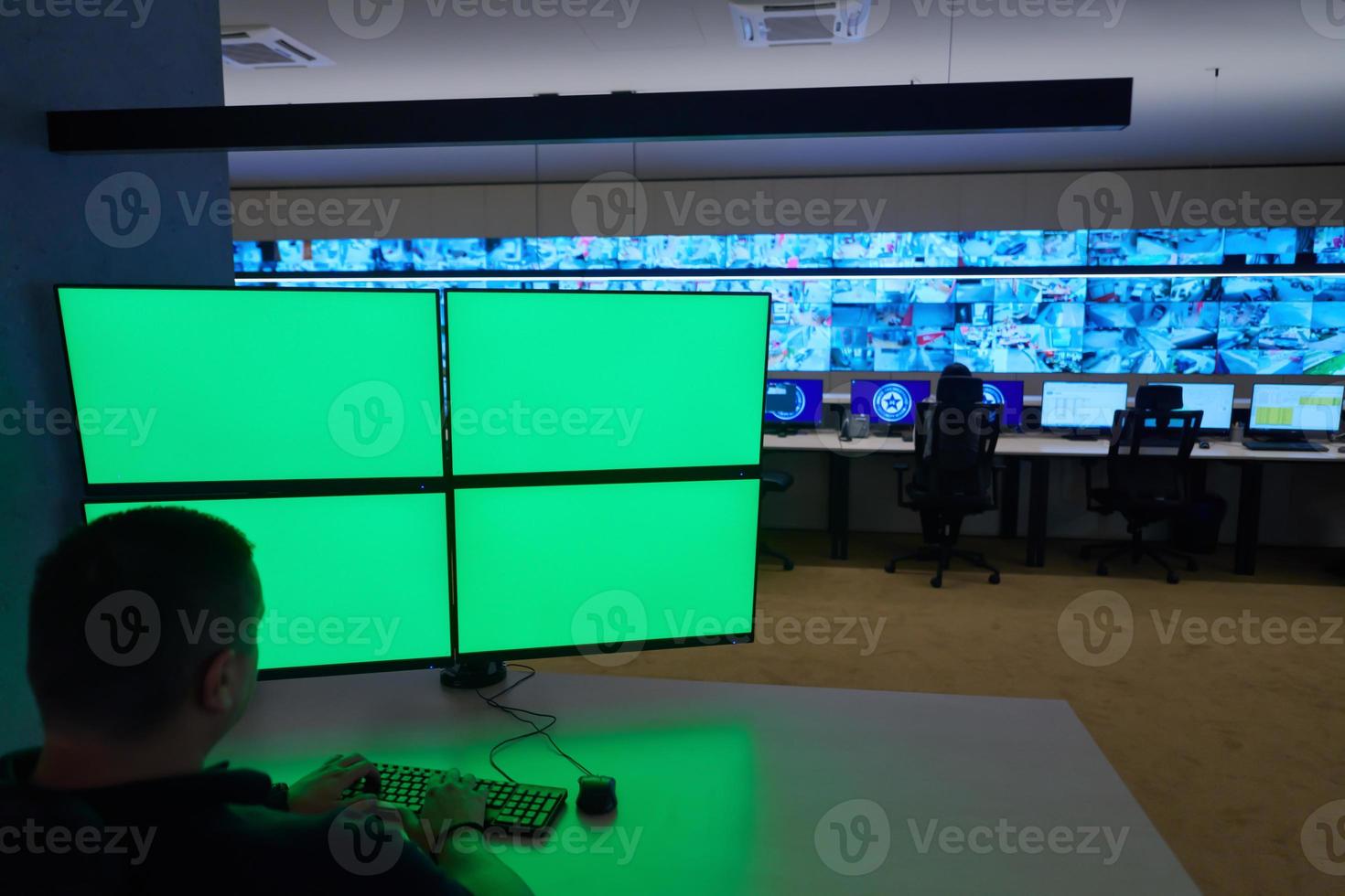 male security operator working in a data system control room photo