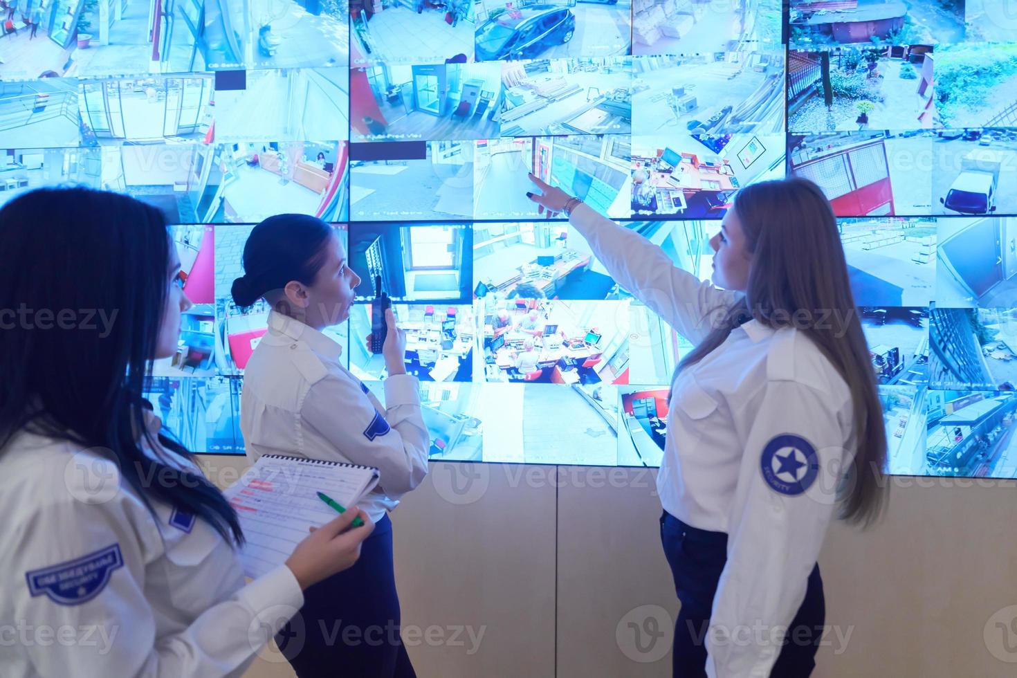 Female security guards working in a security data system control room photo