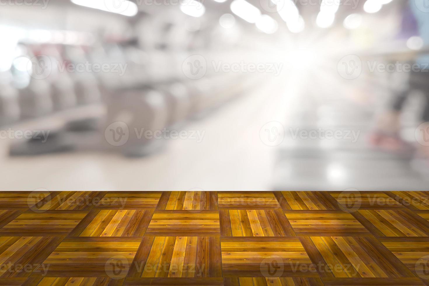 Empty wooden board space platform with blur fitness gym equipment background photo