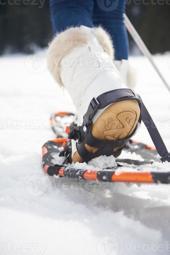 couple having fun and walking in snow shoes photo