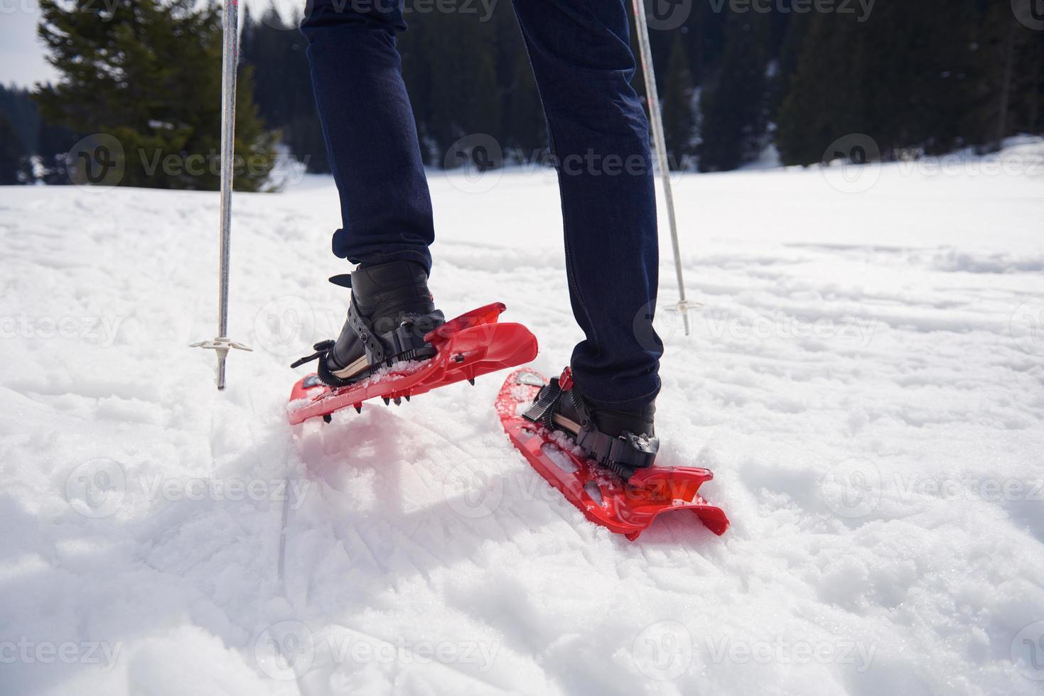 couple having fun and walking in snow shoes photo