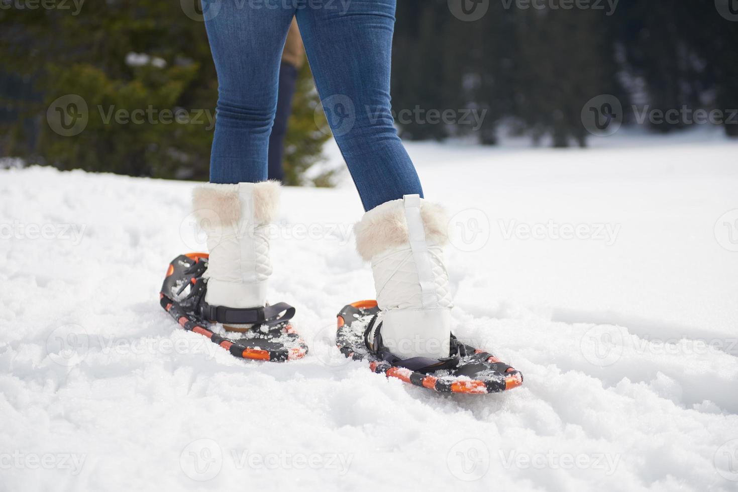 couple having fun and walking in snow shoes photo