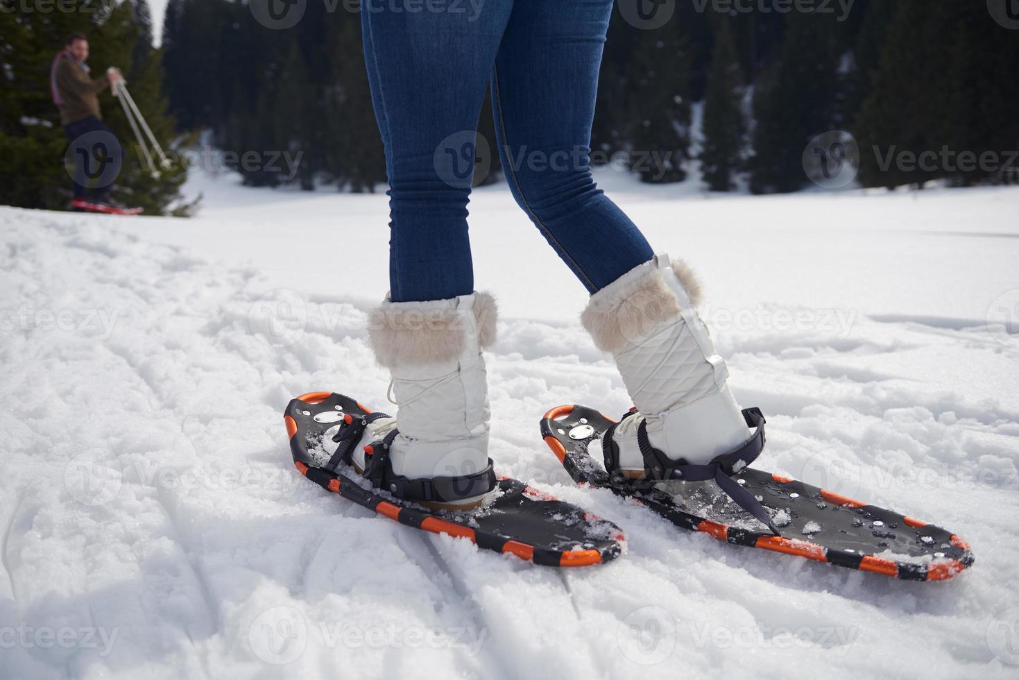 couple having fun and walking in snow shoes photo