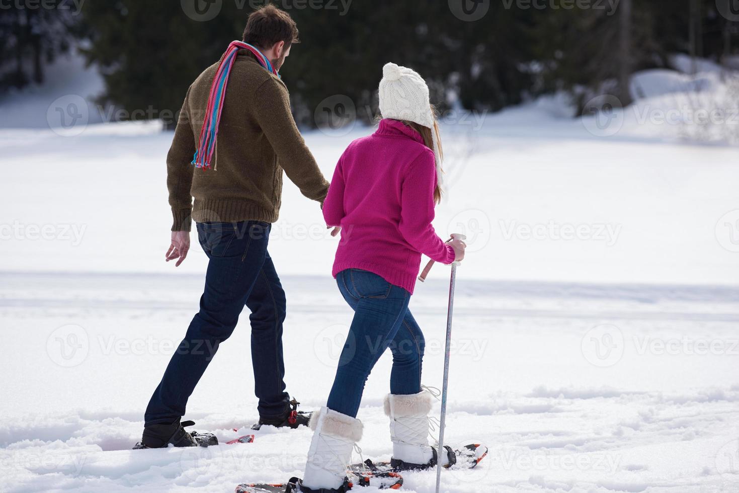 couple having fun and walking in snow shoes photo