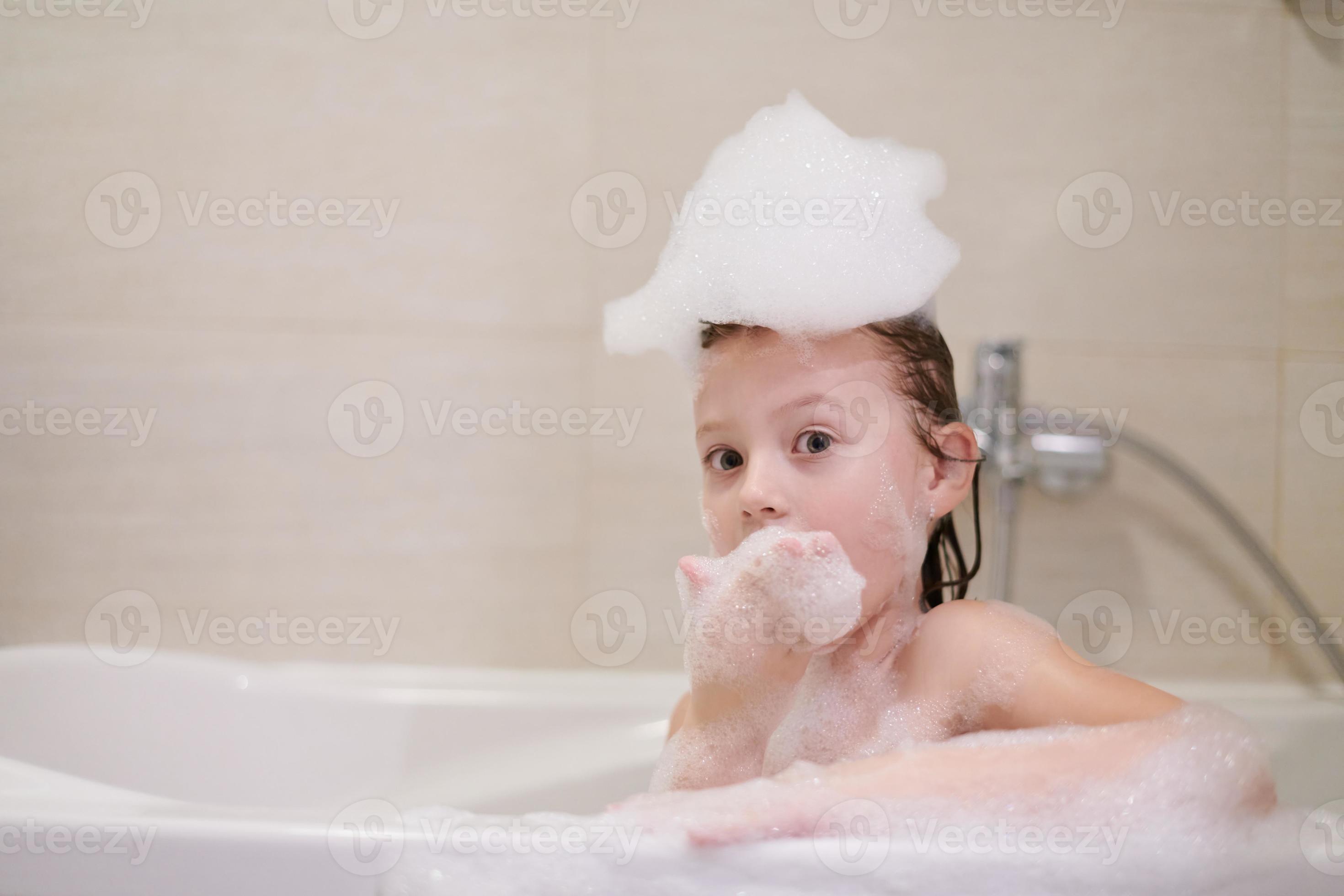 little girl in bath playing with soap foam 10707381 Stock Photo at Vecteezy