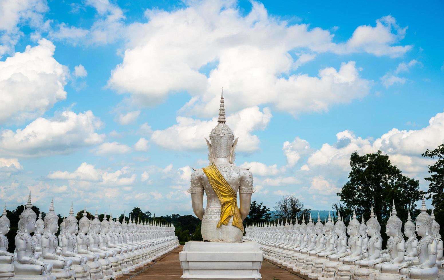 The group of Buddha statue with the beautiful sky and clouds in the unknown temple in the countryside of North East region of Thailand. photo