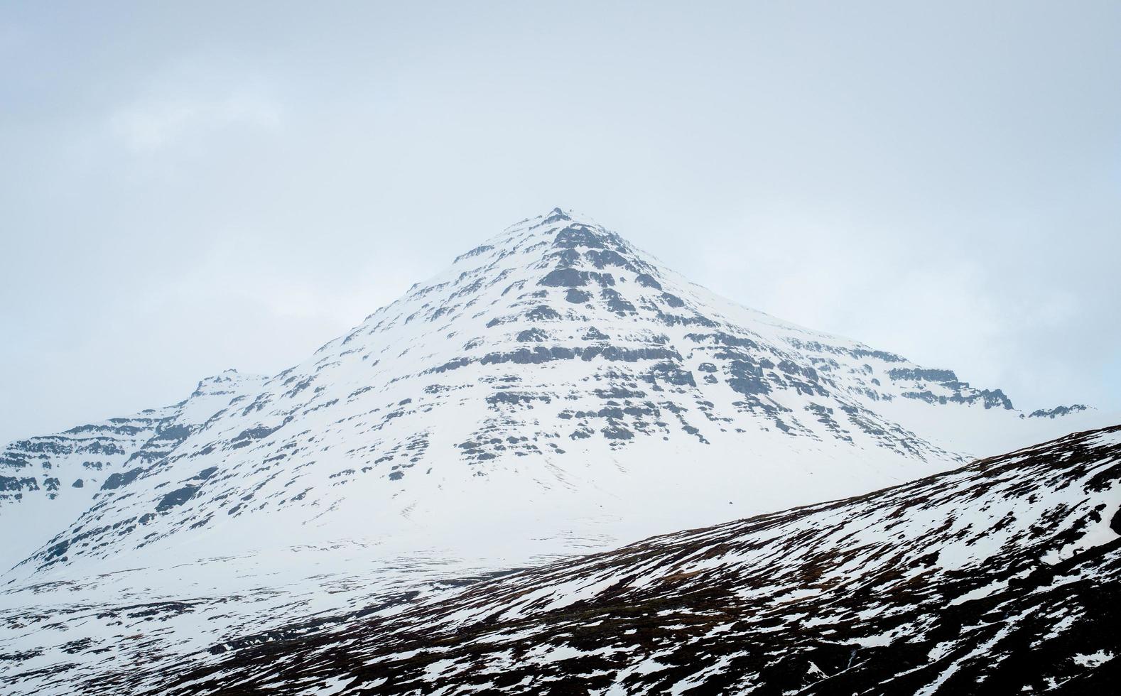 The beautiful scenery of snowy mountain in Stodvarfjordur of East Iceland covered by mist in winter season. photo