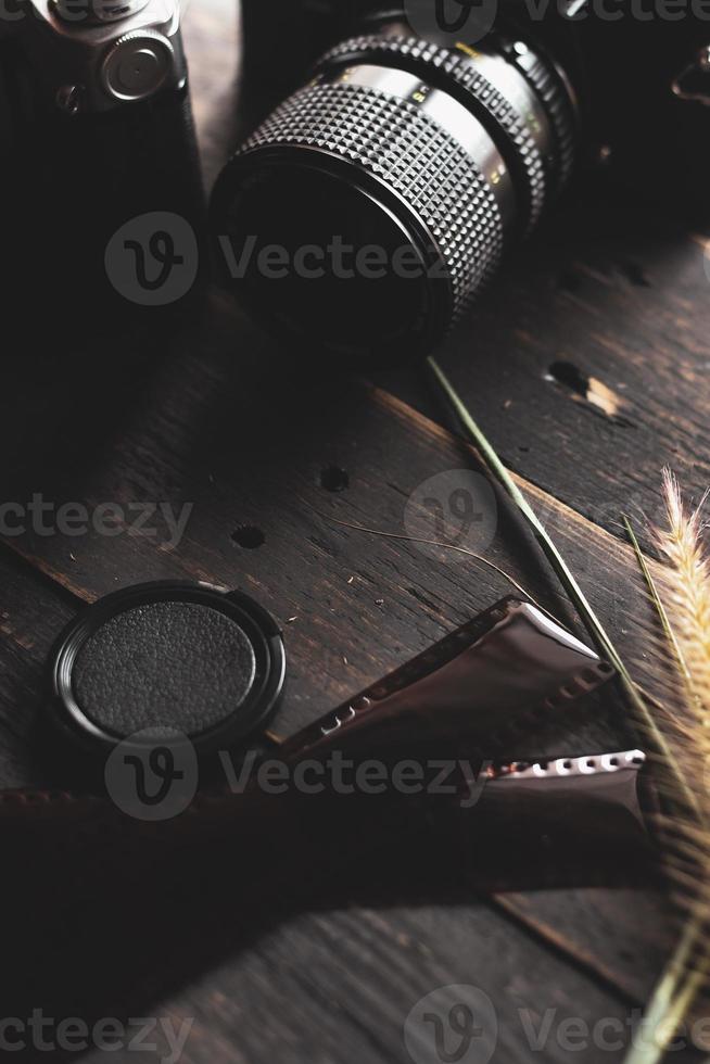 Retro film camera and negative film on a black wooden table photo