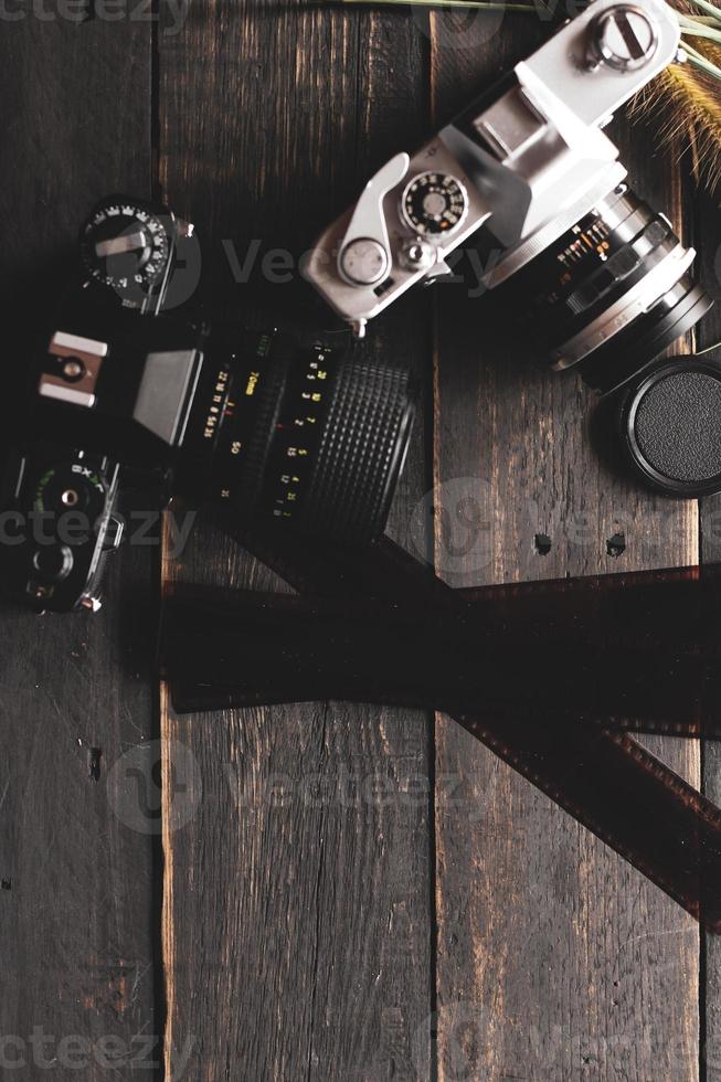 Retro film camera and negative film on a black wooden table photo