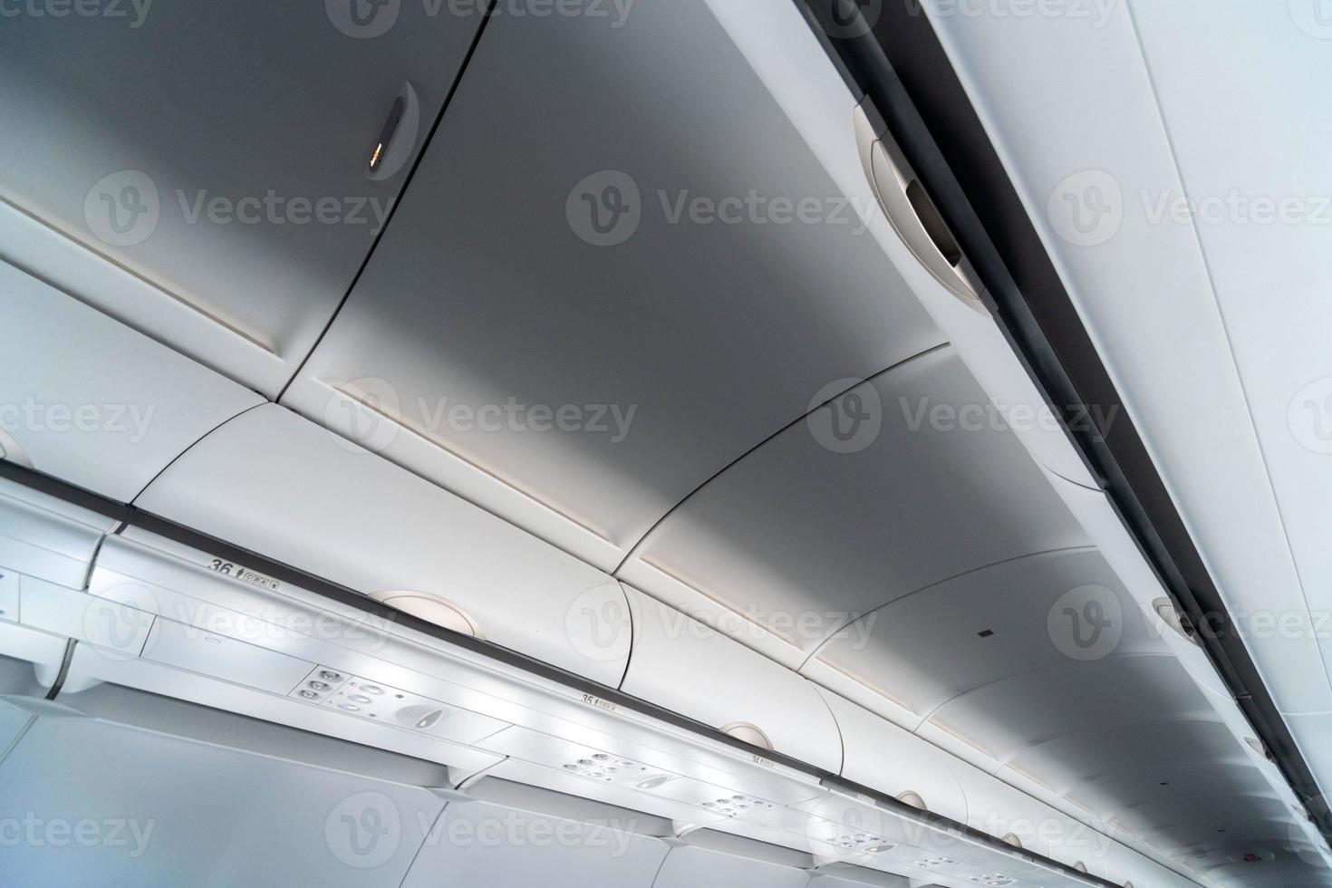 Airplane air conditioning control panel over seats. Stuffy air in aircraft cabin with people. New low-cost airline. photo