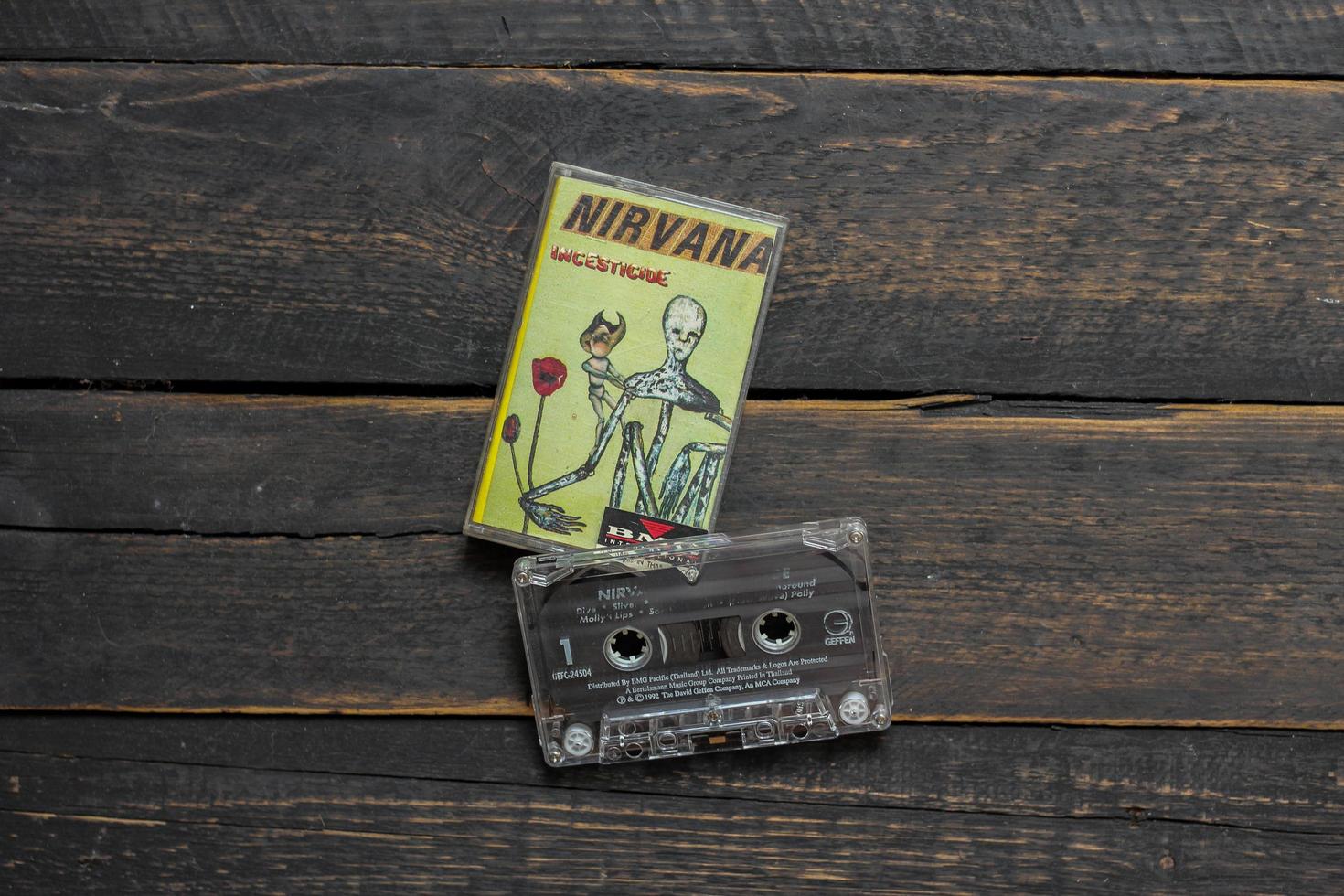 Bangkok, Thailand  January ,22 2022  90's cassette tapes of Nirvana Album Incesticide on a black wooden floor. photo