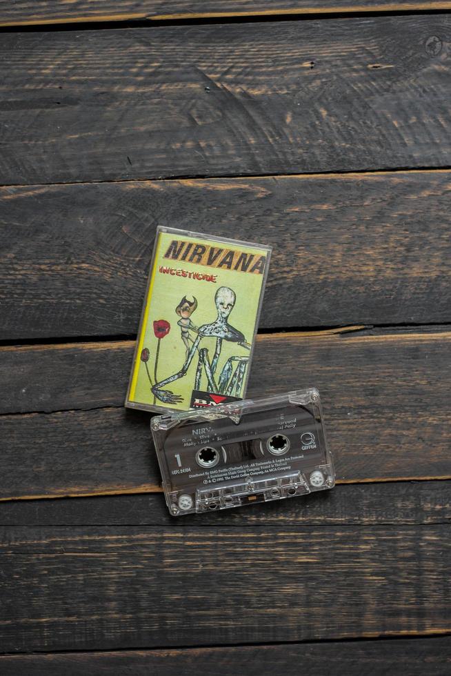 Bangkok, Thailand  January ,22 2022  90's cassette tapes of Nirvana Album Incesticide on a black wooden floor. photo