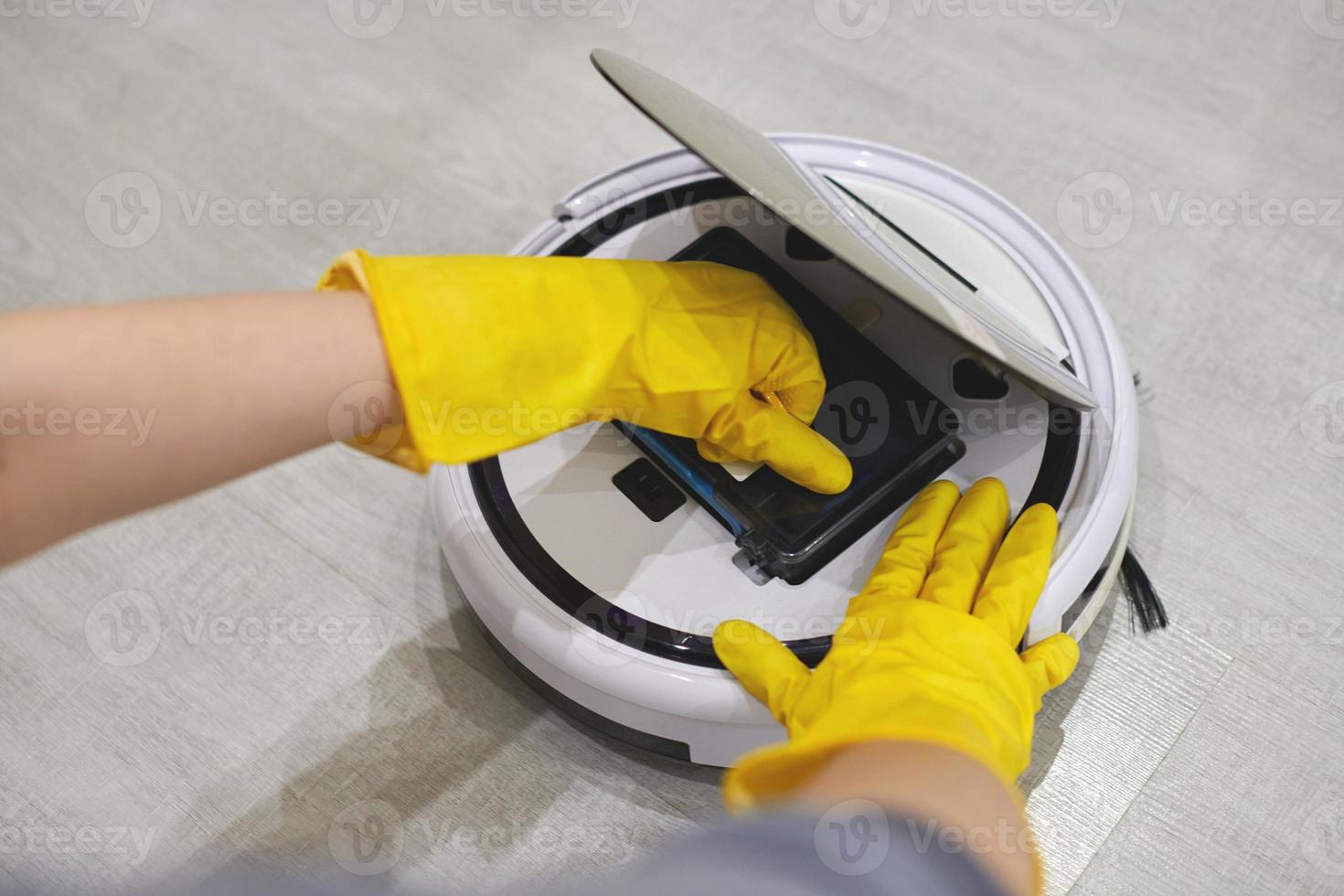 Robot vacuum cleaner, inserting filter, cleaning. Close up. photo