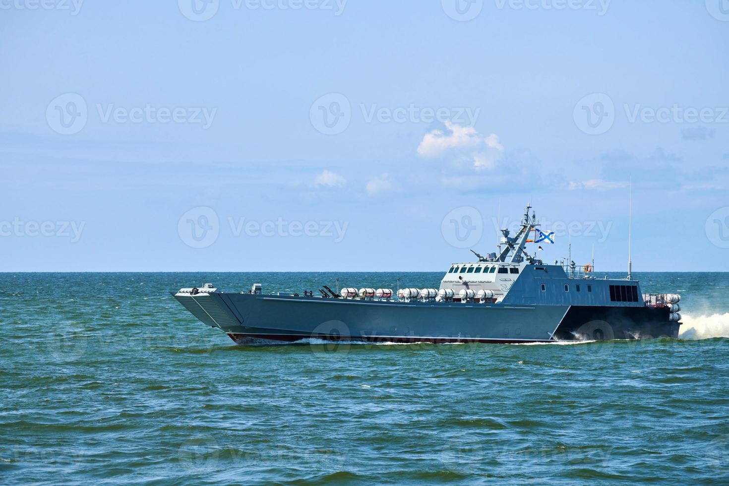 Large modern grey warship sailing in still blue sea water. International security, Russian Navy photo