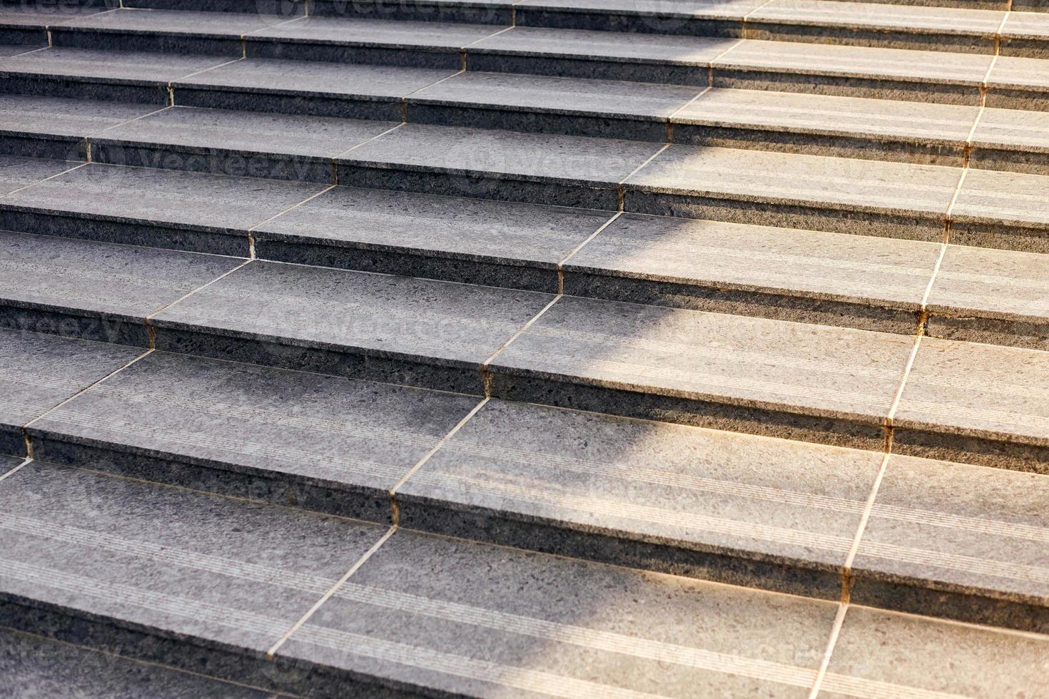 Grey stone steps in modern style, large staircase with stone-like grey texture, wide granite ladder photo