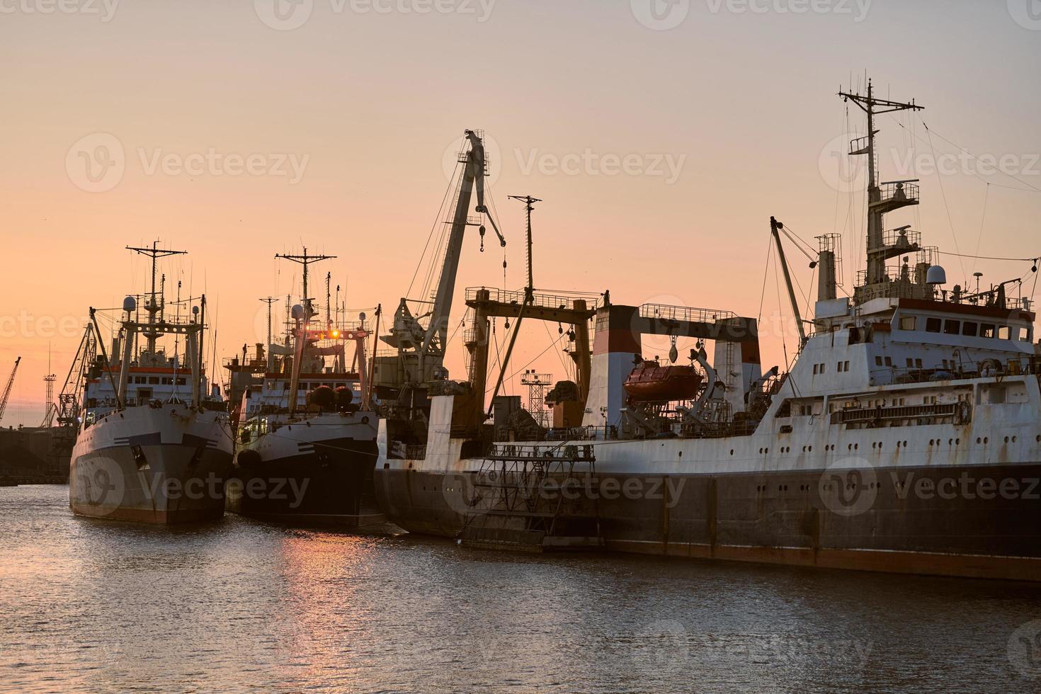 barcos en el puerto de mar en el fondo de la puesta del sol foto