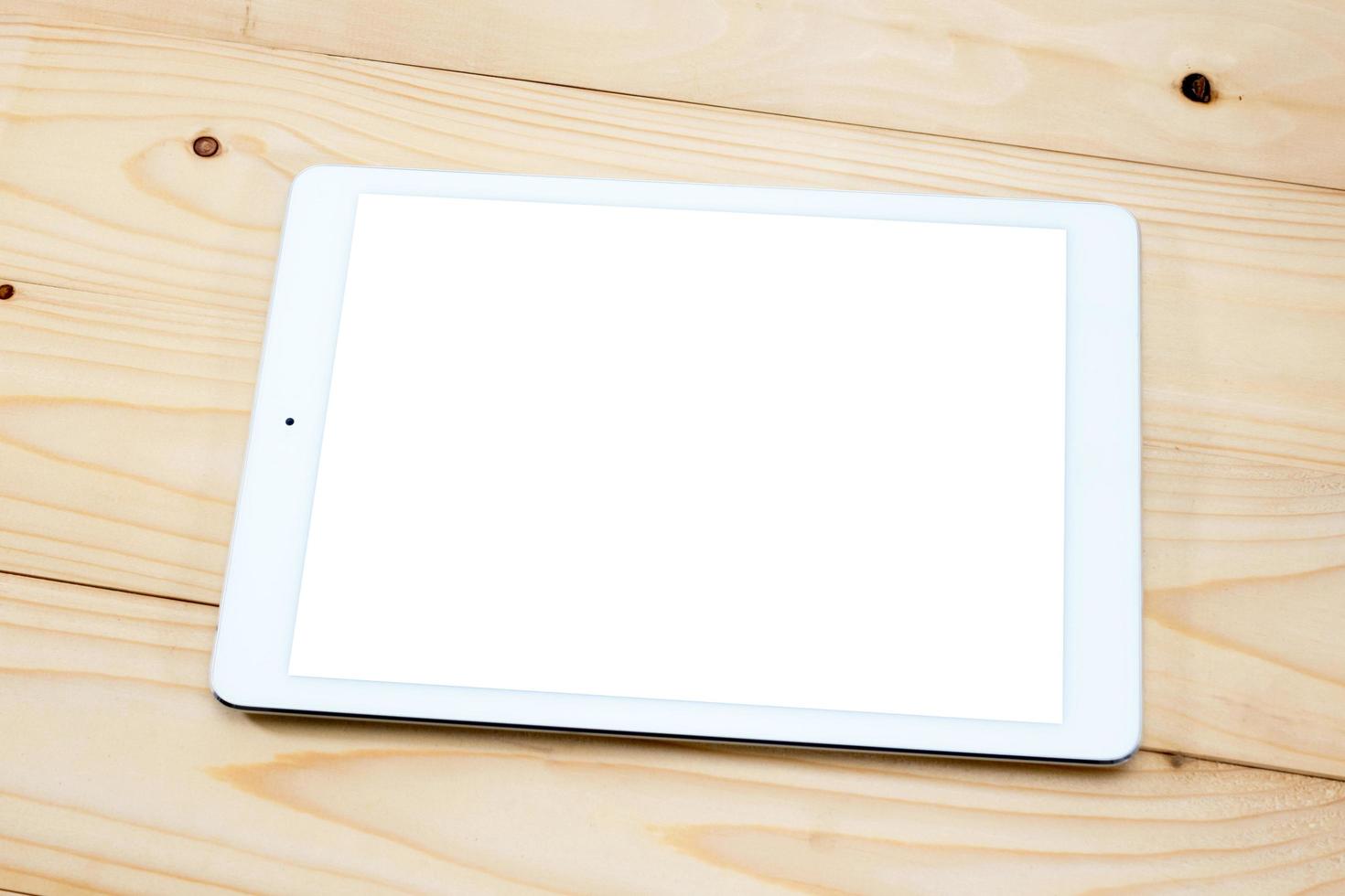 White tablet PC with blank screen on wooden table photo