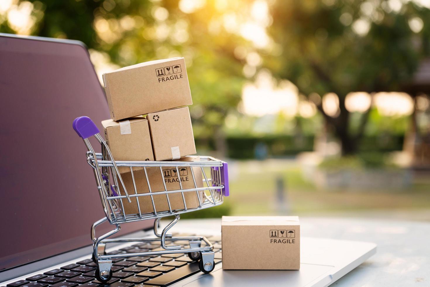 Online shopping or ecommmerce delivery service concept,Paper boxes in a trolley on a laptop computer,Easy shopping online concept photo