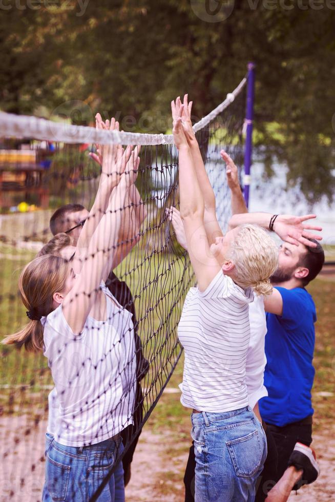 group of young friends playing Beach volleyball photo