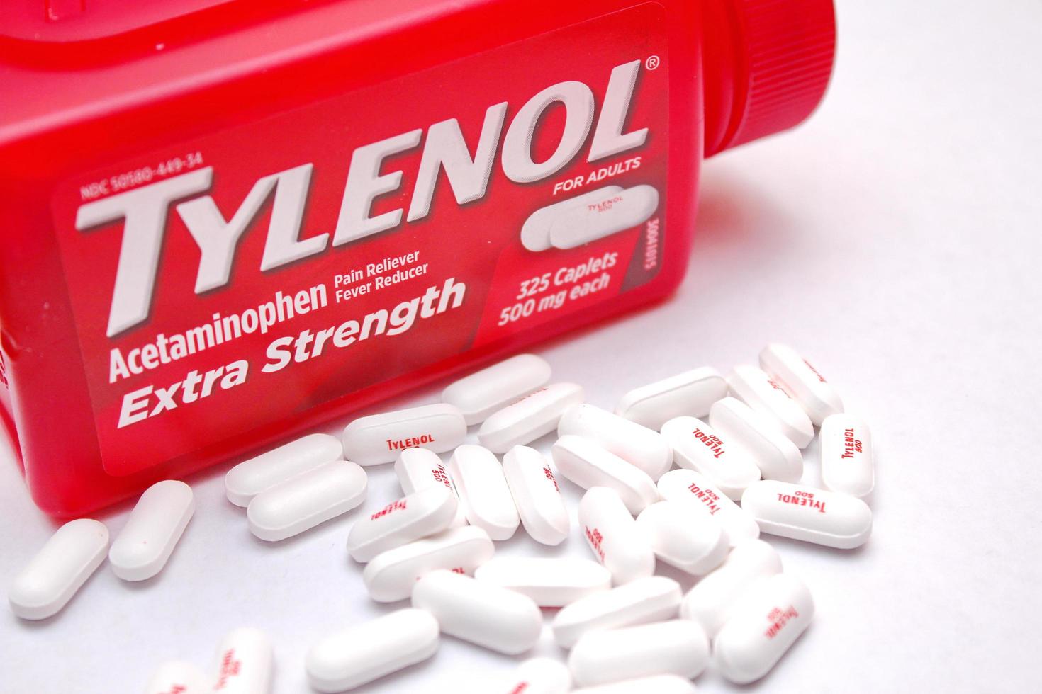 Washington, EE.UU. 21 de julio de 2022 botella de tylenol extra fuerte con muchas pastillas en una mesa de madera que se agotó durante el tiempo de covid-19, dolor de cabeza, analgésicos foto