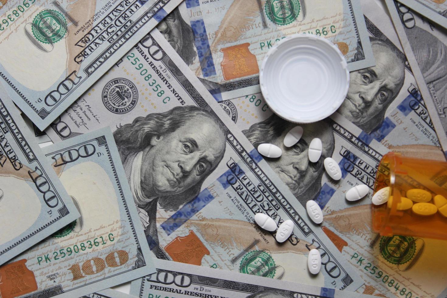 Bangkok Thailand  January 07  2022  Pills and pill bottles scattered on US dollar bills. photo