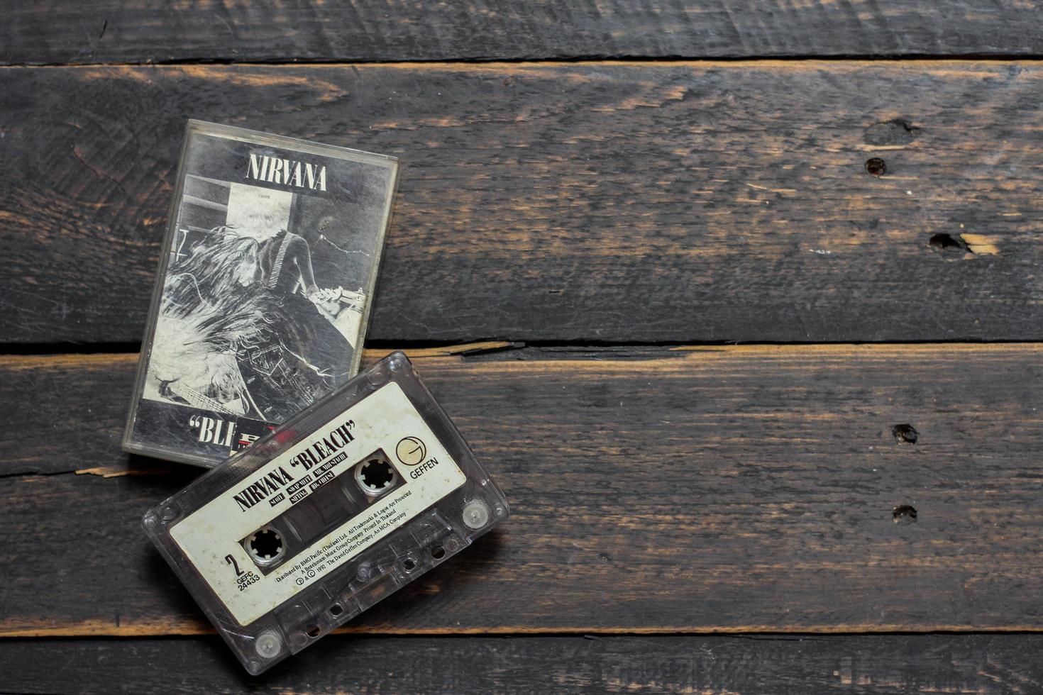 Bangkok, Thailand  January ,22 2022  90's cassette tapes of Nirvana album Bleach on a black wooden floor. photo