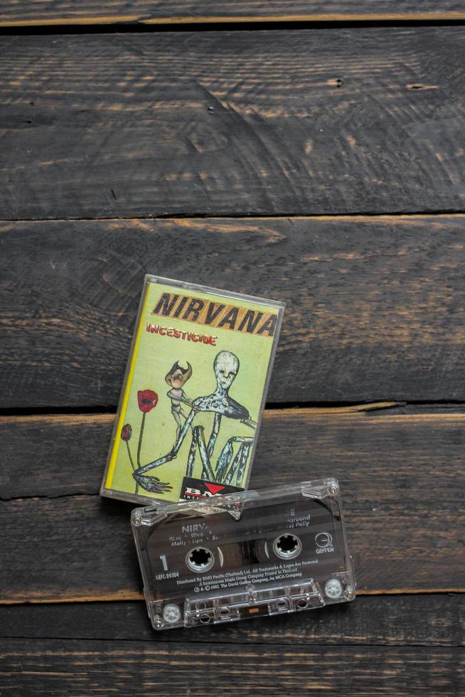 Bangkok Thailand - January ,22 2022  90's cassette tapes of Nirvana Album Incesticide on a black wooden floor. photo