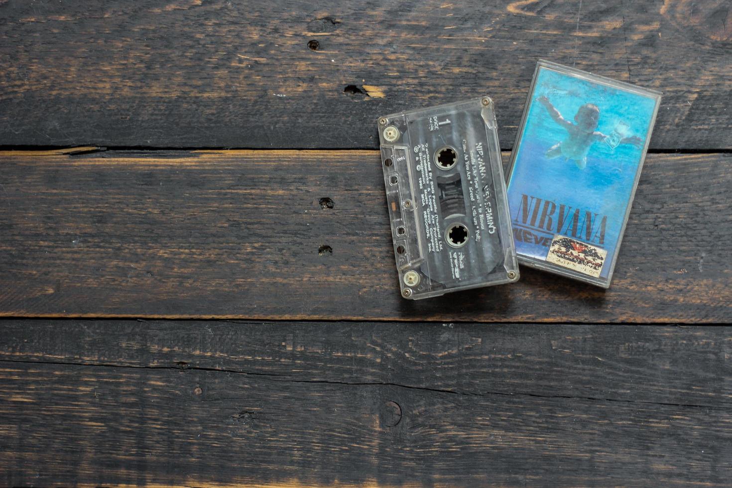 Bangkok, Thailand  January ,22 2022  90's cassette tapes of Nirvana Album Nervermind on a black wooden floor. photo