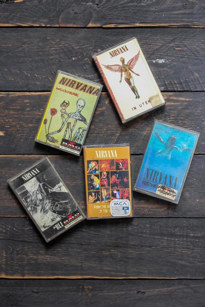 Bangkok, Thailand  January ,22 2022  90's cassette tapes of Nirvana Albums Incesticide, Nevermind, Bleach, From The Muddy Banks of The Wishkah on a black wooden floor. photo