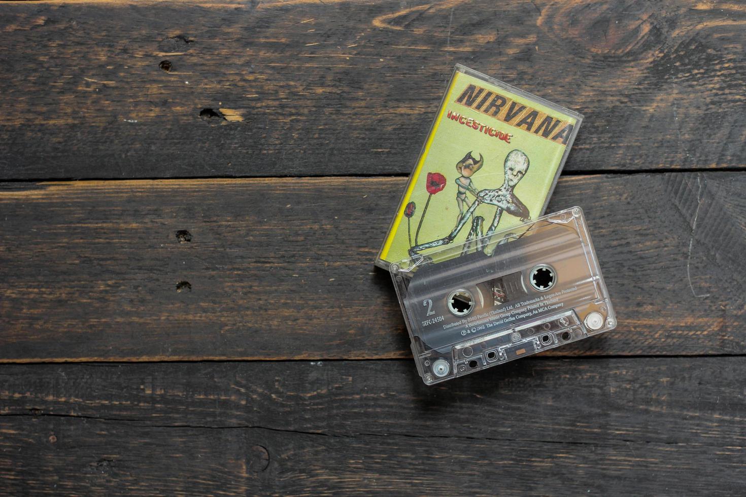Bangkok, Thailand  January ,22 2022  90's cassette tapes of Nirvana Album Incesticide on a black wooden floor. photo
