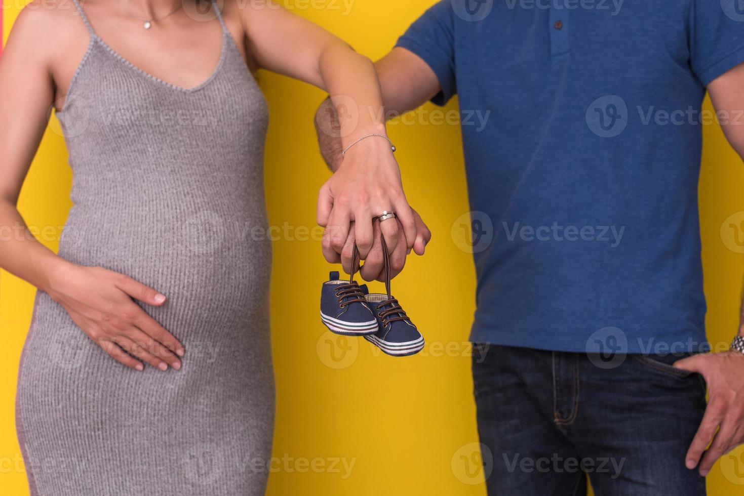 couple holding newborn baby shoes photo