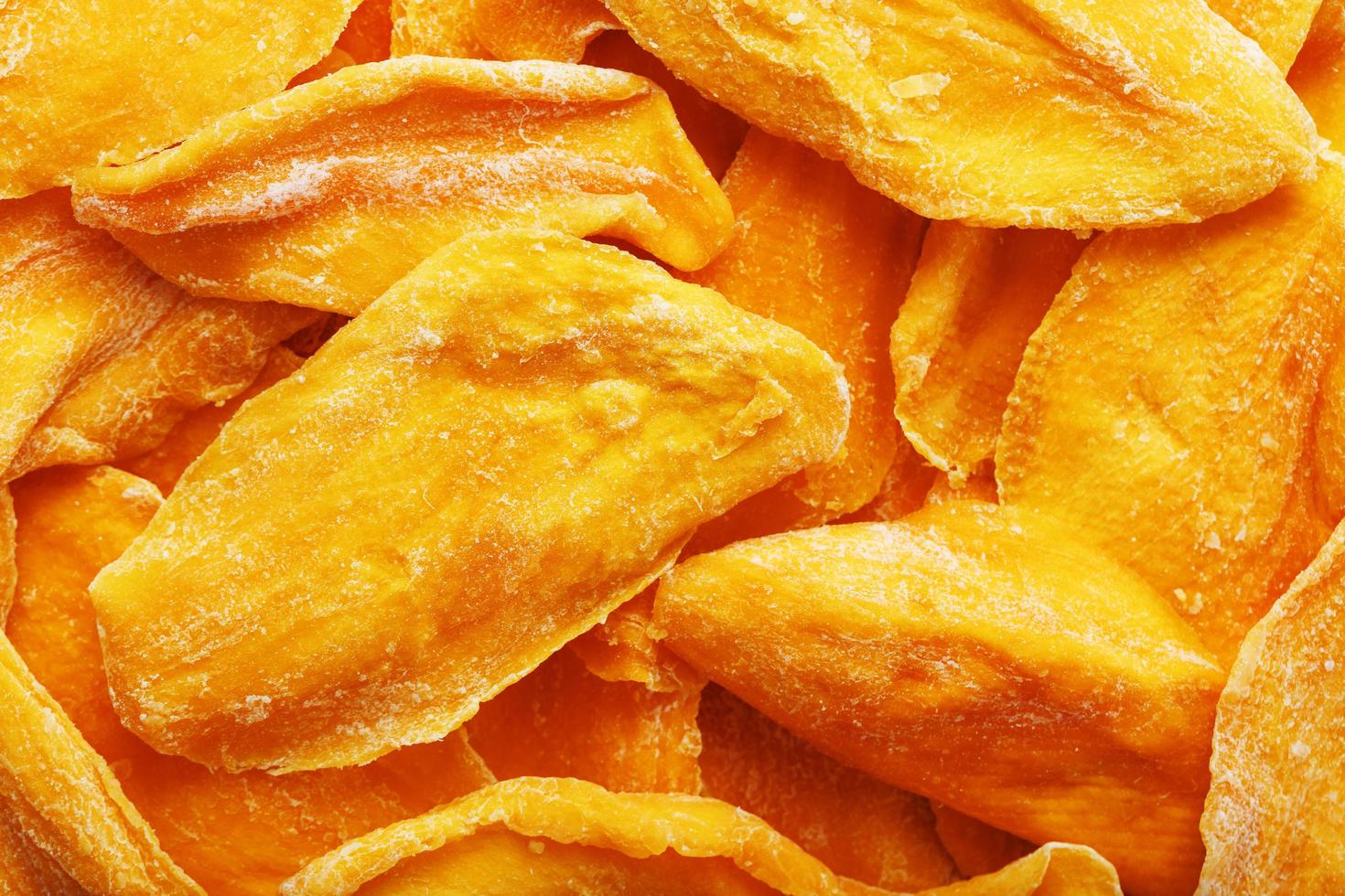 Pieces of sweet dried mango close-up as a background in full screen photo