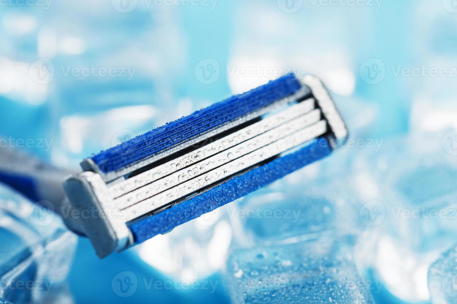 Blue shaving machine with sharp blades on the background of ice cubes close-up photo