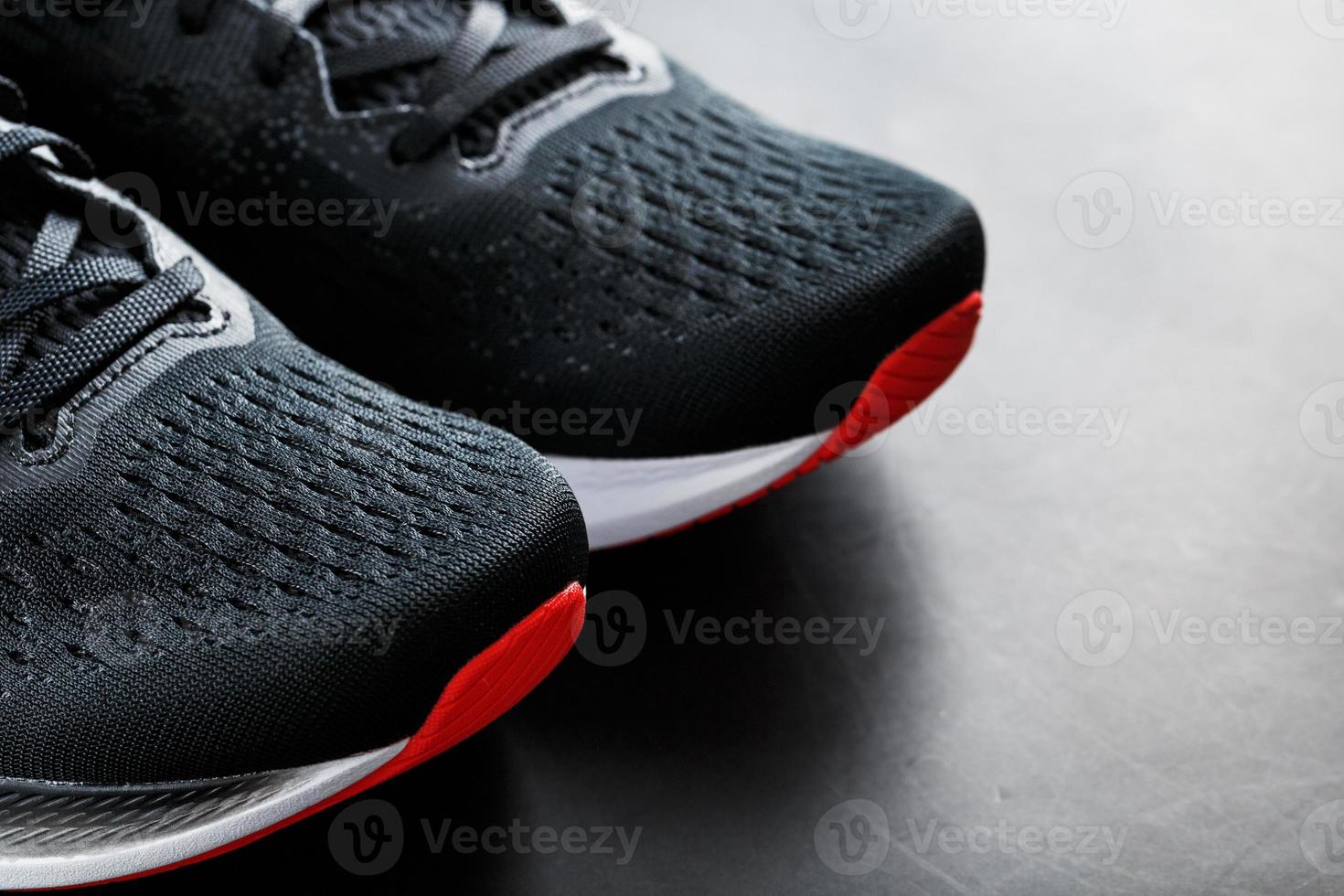 Black sports sneakers with red soles on a black background. photo