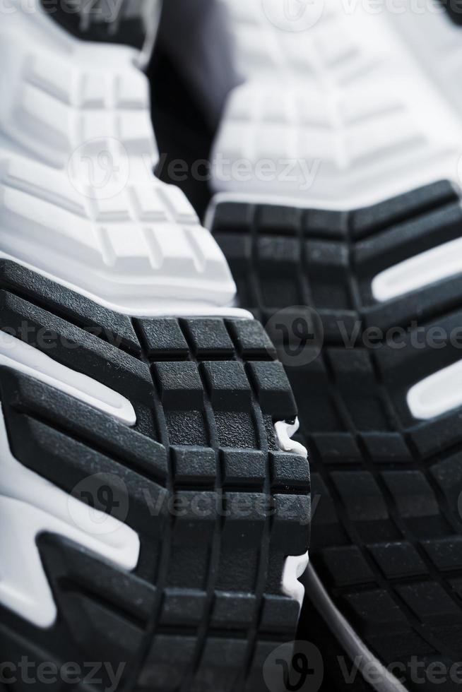 The black and white sole of trendy sports sneakers is a close-up in full screen. photo