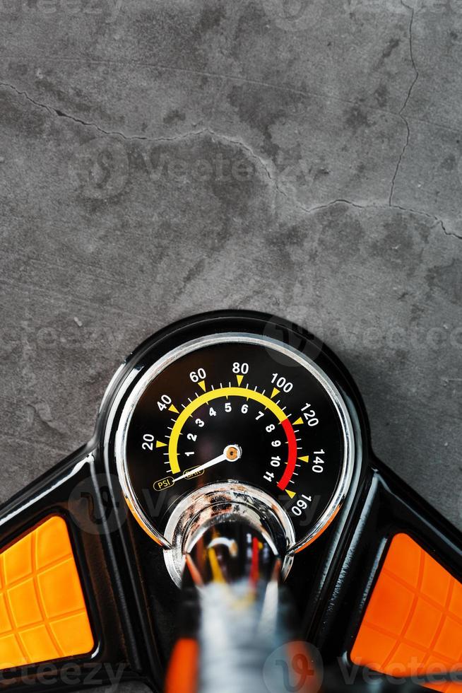 Air pump with a manometer and a wheel inflation hose on a dark background with free space photo