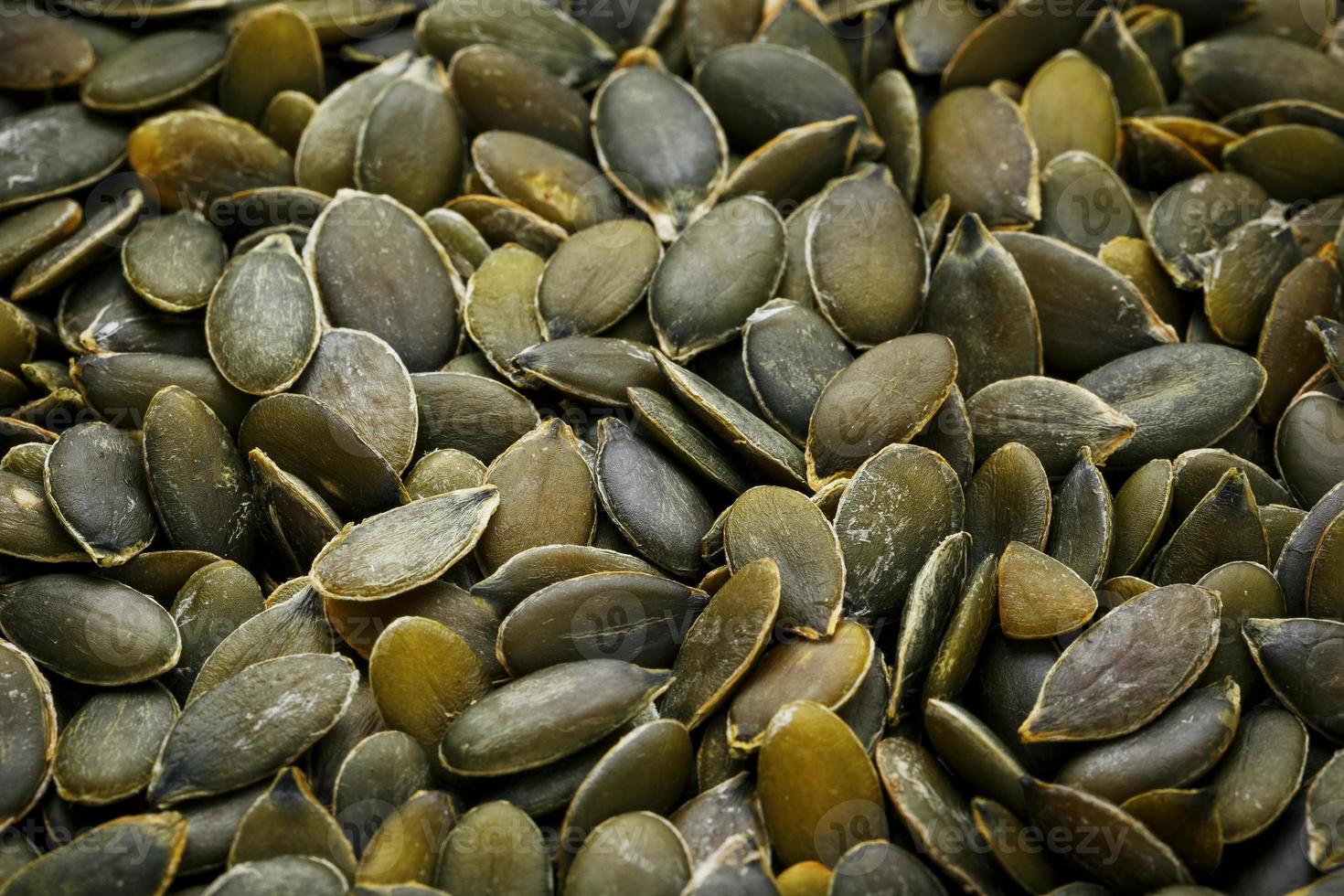 Macro background texture of green pumpkin seeds photo