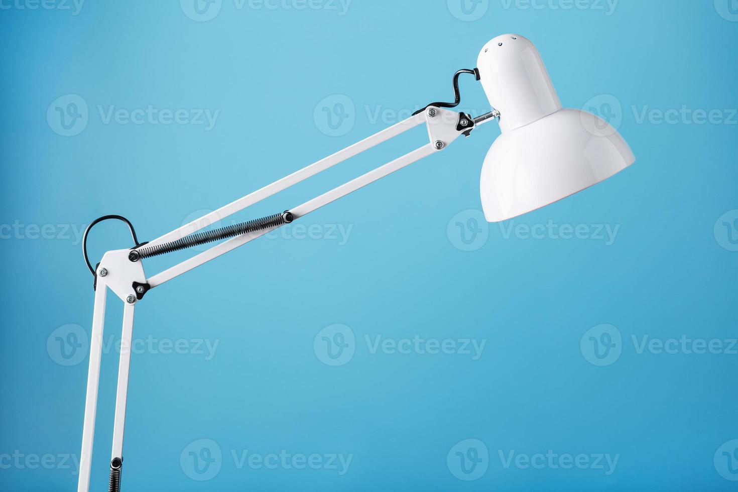 White table office lamp on blue background with space for text and idea concept photo