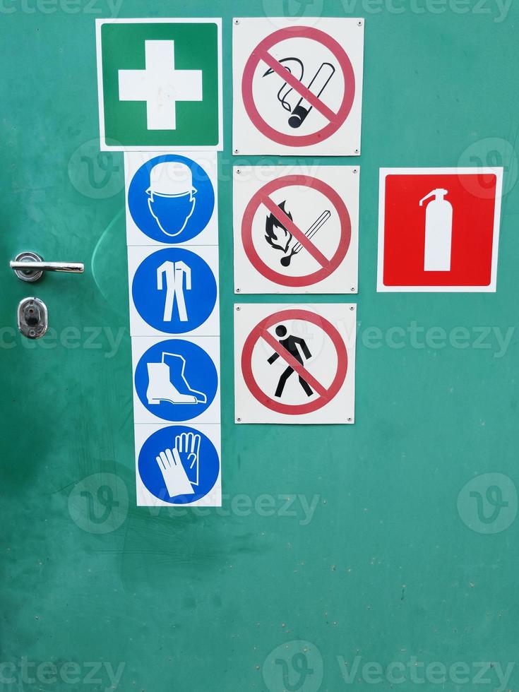 Safety signs on a green door for warning photo