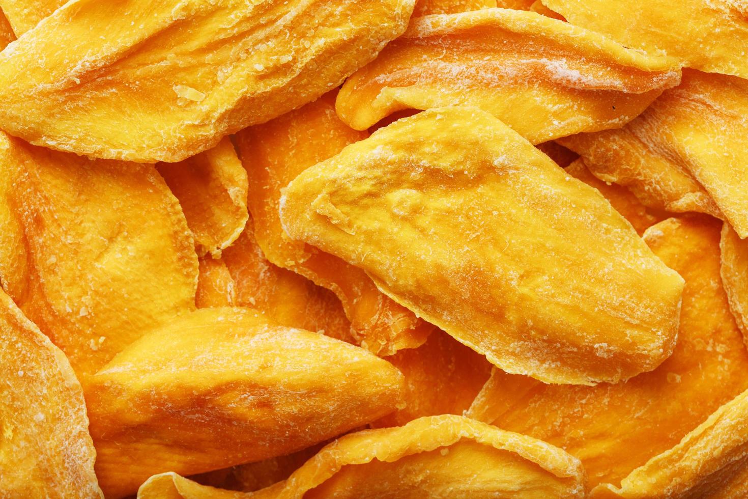 Pieces of sweet dried mango close-up as a background in full screen photo