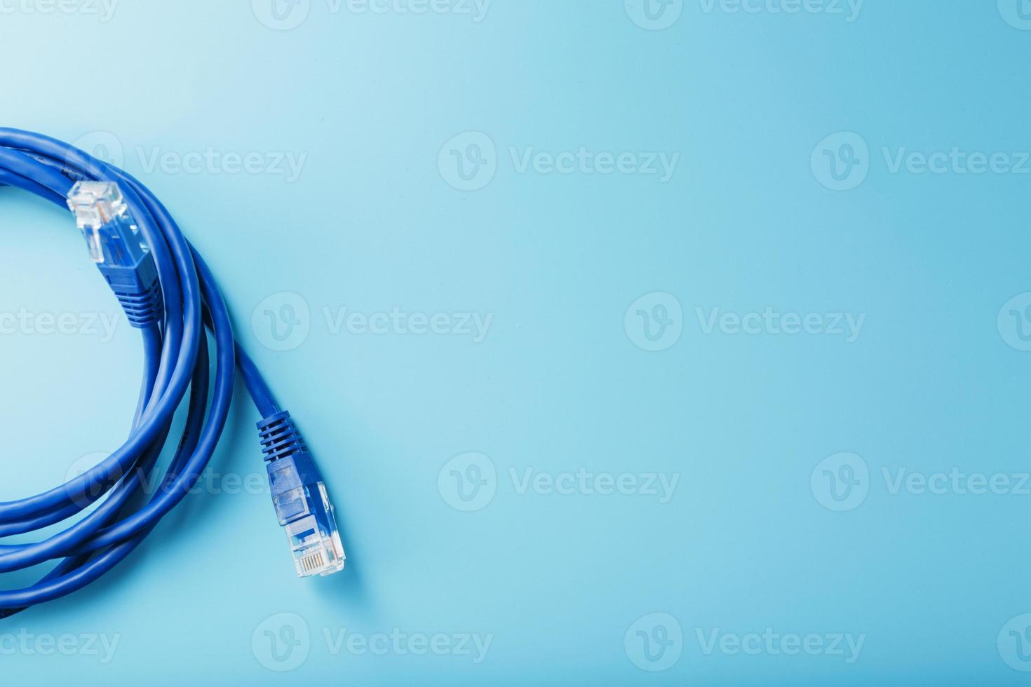 una bobina de un cable de red de Internet para la transmisión de datos sobre un fondo azul foto