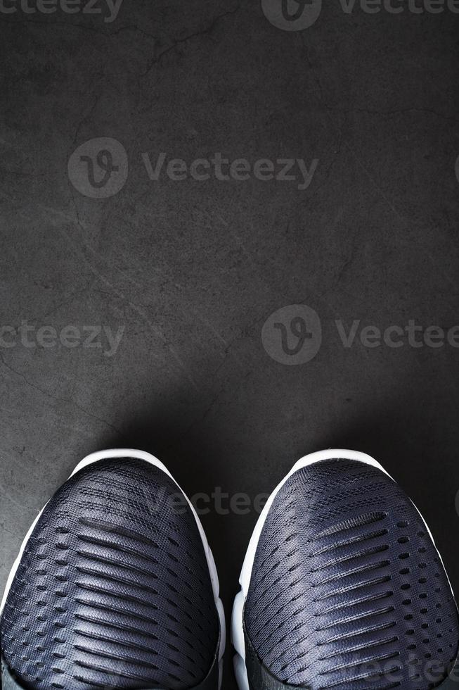 Running shoes with mesh and black and white soles close-up on a dark background. photo