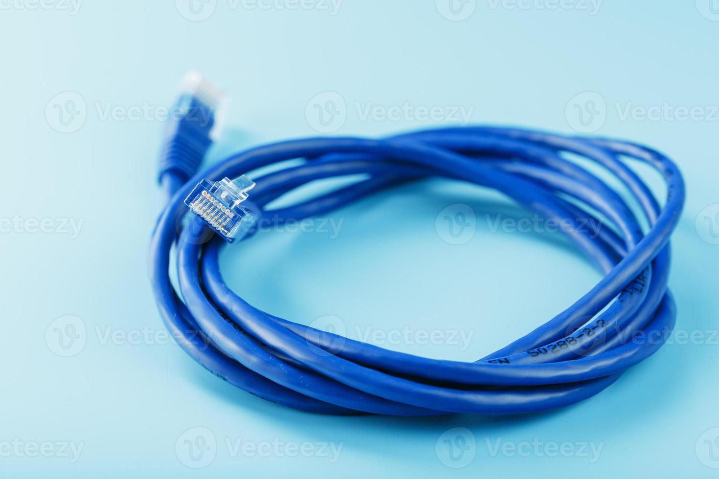 una bobina de un cable de red de Internet para la transmisión de datos sobre un fondo azul foto