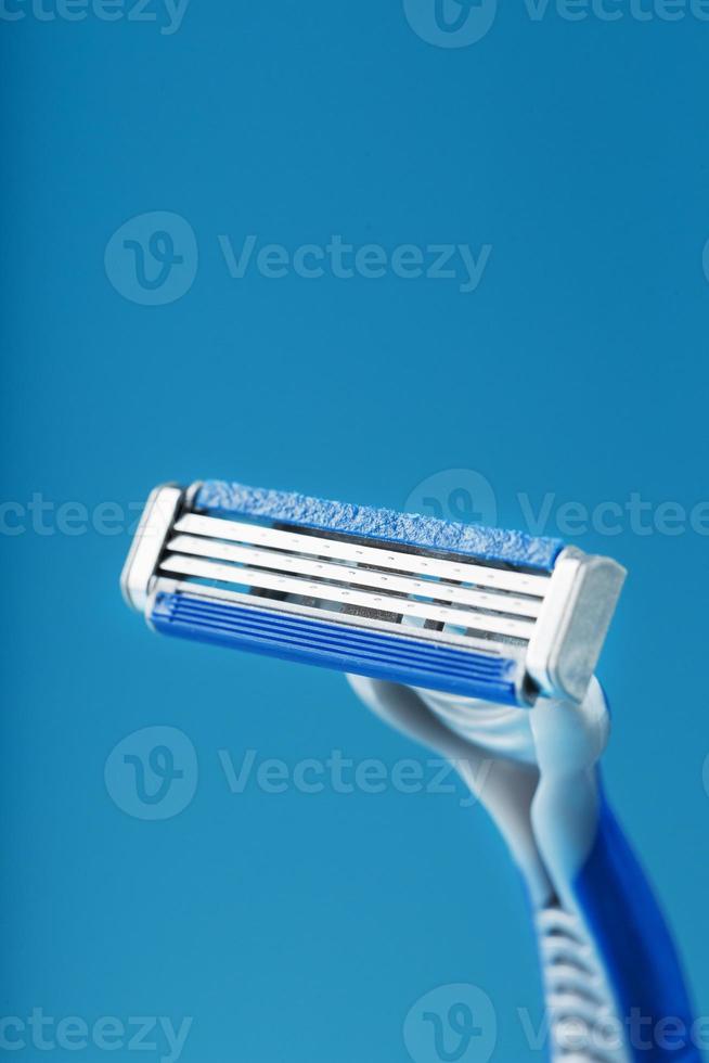 máquina de afeitar con tres cuchillas en un espacio libre de primer plano de fondo azul foto