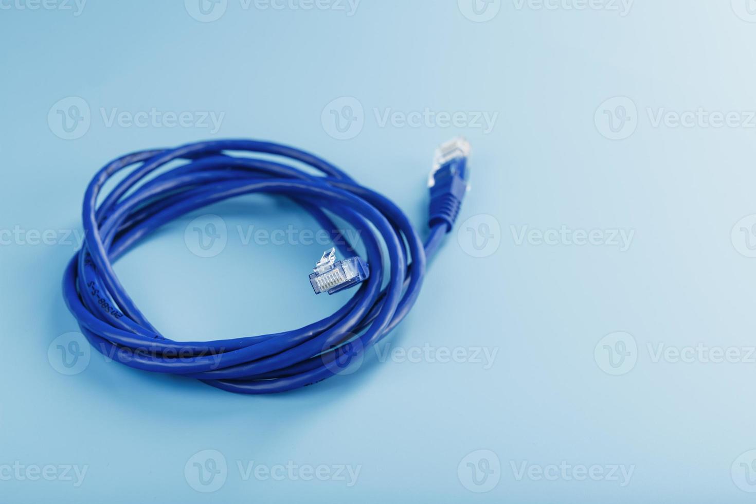 una bobina de un cable de red de Internet para la transmisión de datos sobre un fondo azul foto