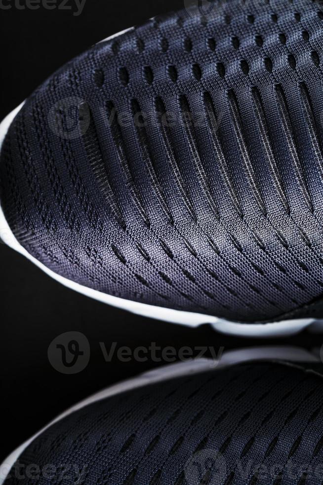 Black and white ultra-modern sports sneakers on a black background. photo