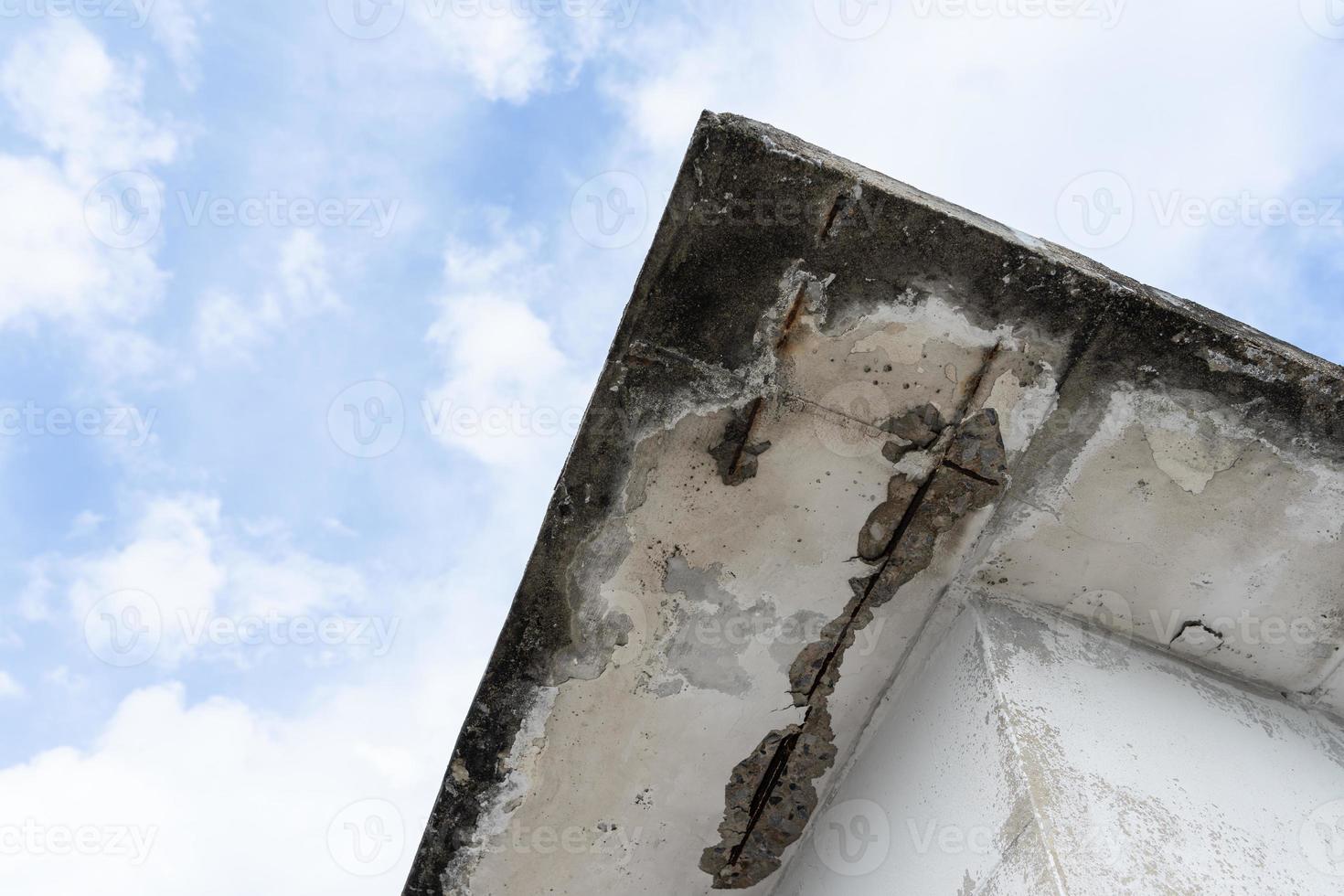 Water damaged ceiling roof in an old house. Water damage building interior. Ceiling house broken. Ceiling concrete crack and exposed the rusty steel bar frame. photo